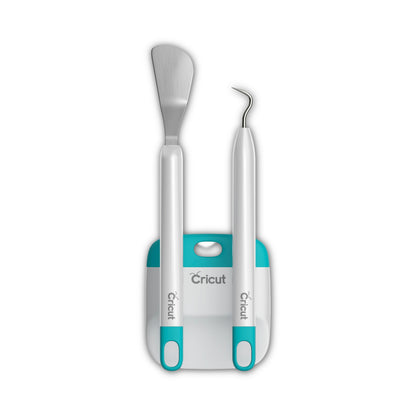 Two Cricut crafting tools with white handles and teal accents, standing upright in a matching white and teal stand against a plain white background.